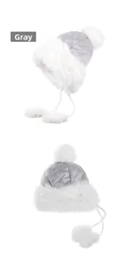 Close-up of quilted grey velvet earflap hat with white faux fur trim and plush pom-poms