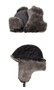 Detail of winter trapper hats with grey faux fur lining in dark grey and quilted black fabric