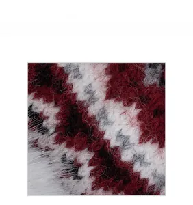 Macro shot of thick winter knit fabric with red and white plaid pattern texture