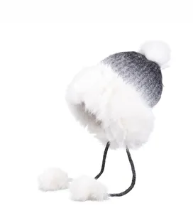 Close-up of winter knit hat with white faux fur lining and gradient grey finish