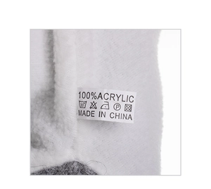Close-up of fluffy white faux fur texture and laundry label showing 100% acrylic material