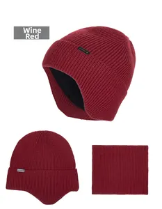 Detail view of wine red knitted beanie and neck warmer with warm fleece lining and metal tag