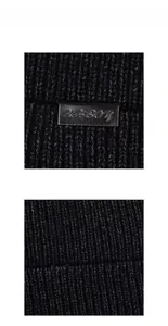 Close-up of black cable knit texture with embossed leather brand patch details