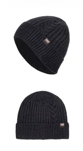 Detail view showing textured cable knit patterns and a brand label on a gray winter beanie