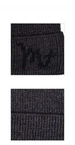 Macro shot of dark grey rib-knit winter hat fabric and fuzzy textured embroidered detail