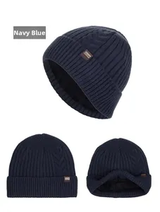 Detail view of navy blue cable knit beanie with thick black fleece lining and leather label
