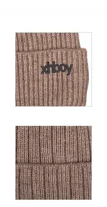 Detailansicht der braunen Rippstrickstruktur und des schwarzen xhboy-Logos auf der Mütze