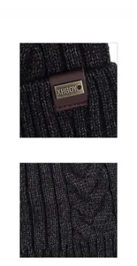 Detailed view of dark grey thick knit beanie with leather logo patch and metal emblem