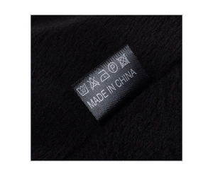 Macro detail of the interior wash label and thick fleece lining of this black winter hat