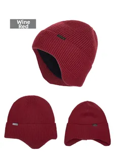 Detail view of wine red knit hat with thick ear flaps and warm black fleece lining