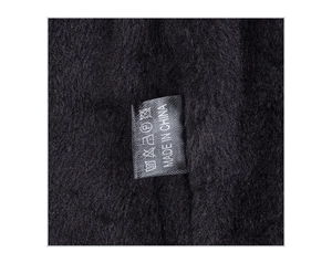 Detail of warm black fleece lining and sewn wash label on a winter knitted beanie