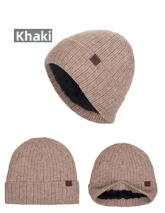 Dettaglio del berretto in maglia kaki con calda fodera in pile nero e logo in pelle