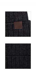 Vista macro del tessuto a maglia grigio scuro e dell'etichetta in pelle goffrata con logo