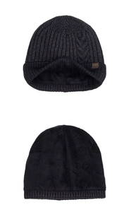Detail of warm cable knit beanie with thick black fleece lining and brown leather patch