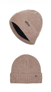 Detail view of khaki knit beanie featuring warm black fleece lining and side logo patch