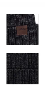 Macro shot of dark gray ribbed knit texture and brown leather label detail on winter hat