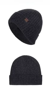 Detail of warm winter knit beanie with thick fleece lining and brown leather logo tag