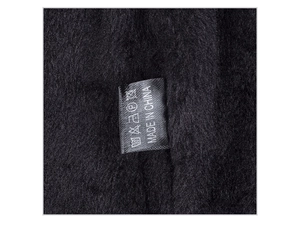 Detailed macro view of black thermal fleece lining and care label for winter beanie
