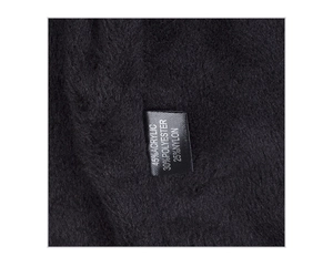Close-up of winter knit hat fleece lining with material label showing acrylic fabric