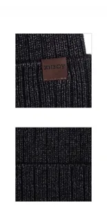 Detailed macro view of dark grey ribbed knit fabric with leather logo tag