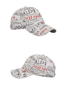 Gros plan sur la casquette beige avec motifs de lettres graffitis noirs et rouges
