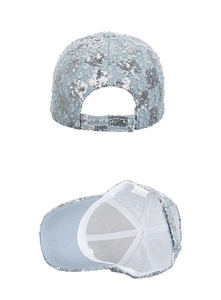 Close-up of light blue denim baseball cap with silver sequins and 100% polyester care label