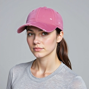 Detail einer rosa gewaschenen Baumwollkappe mit abgenutzter Krempe und Fransenrändern