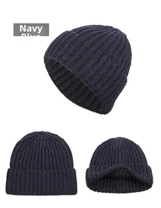 Detail view of navy blue knitted beanie showing thick texture and folded cuff design