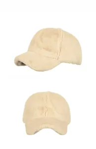 Detailed view of plush beige faux fur winter baseball cap with soft velvet texture