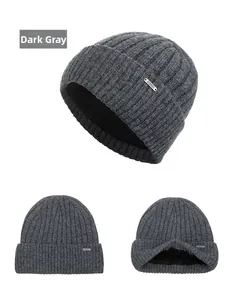 Detail of dark grey knit beanie showing ribbed texture, metal logo and fleece lining