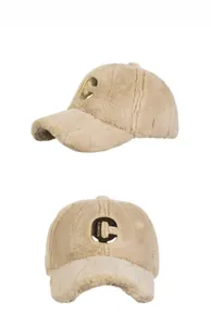 Detail der beige Plüsch-Baseballkappe mit großem goldenem C-Metallbuchstaben-Dekor