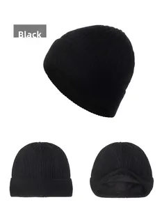 Dettaglio del berretto in maglia nera con motivi a trecce e calda fodera in pile