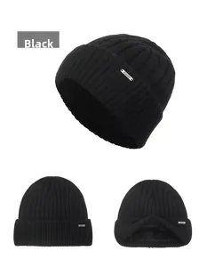 Detail of black wool knit beanie with fleece lining and silver metal ornament