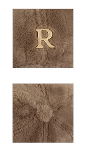 Close-up of brown plush hat with a gold metal 'R' logo and premium faux fur texture