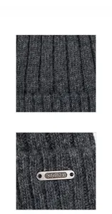 Detailed close-up of dark grey thick knit beanie featuring oval metal logo tag