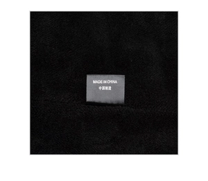 Detailed macro shot of the Made in China fabric label on a black winter beanie hat