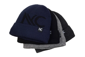 Flat lay stack of thick knit beanies in navy blue, black, and gray with NC letter patterns