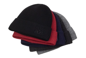 Détail de quatre bonnets en maille côtelée en noir, rouge, bleu et gris avec broderie M