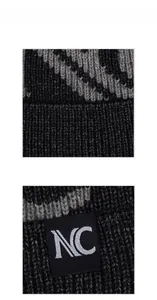 Close-up of thick grey and black knit texture with square NC logo patch detail