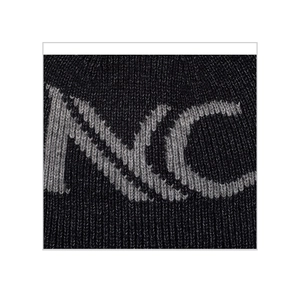 Macro detail of knit beanie showing thick grey MC jacquard lettering and wool texture
