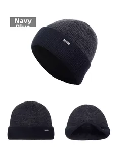 Detail view of navy blue knitted beanie with metal logo tag and warm inner lining