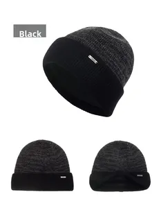 Detailed view of black knitted beanie with thick folded cuff and small metal accent
