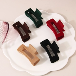 Set of five velvet rectangular claw clips in deep autumn colors on a ceramic tray