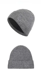 Détail d'un bonnet en maille grise avec broderie M et doublure polaire noire épaisse