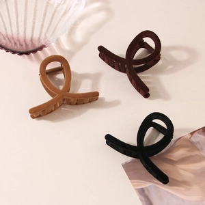 Detail of matte flocked hair claw clips in caramel, dark brown and black colors