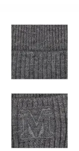 Détail de la texture en maille côtelée gris foncé et de la broderie de la lettre M sur le bonnet