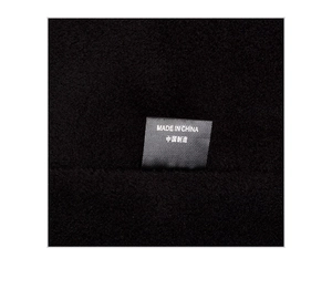 Close-up of the black woven label featuring Made in China text on knitted winter hat