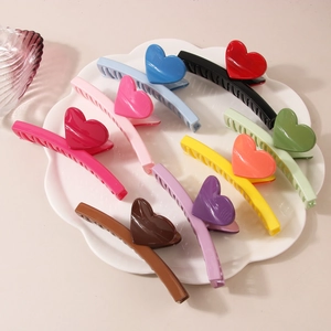 Détails de pinces à cheveux colorées avec cœurs 3D dans un plat en céramique blanche