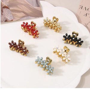 Dettaglio di sei mollette per capelli floreali colorate con perle e strass brillanti