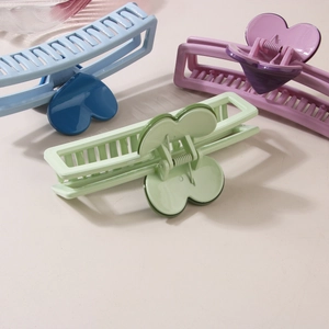 Minimalist heart-shaped hair claw clips in pastel blue, purple, and mint green colors